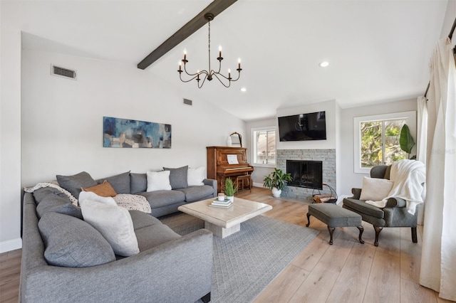 living room featuring a notable chandelier, plenty of natural light, light wood-style flooring, and visible vents