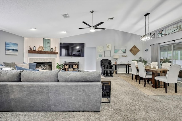 13373 Lawrence St, Spring Hill, FL 34609 - living area with visible vents, a ceiling fan, a glass covered fireplace, and vaulted ceiling