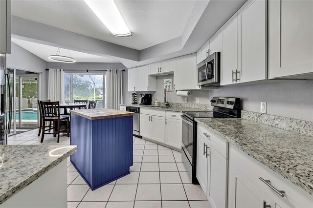 13373 Lawrence St, Spring Hill, FL 34609 - kitchen featuring white cabinets, light tile patterned flooring, a sink, wood counters, and stainless steel appliances