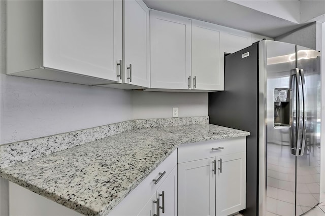 13373 Lawrence St, Spring Hill, FL 34609 - kitchen featuring white cabinets, light stone countertops, and stainless steel fridge with ice dispenser
