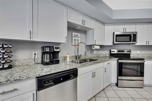 13373 Lawrence St, Spring Hill, FL 34609 - kitchen with stainless steel appliances, light stone countertops, white cabinetry, and a sink