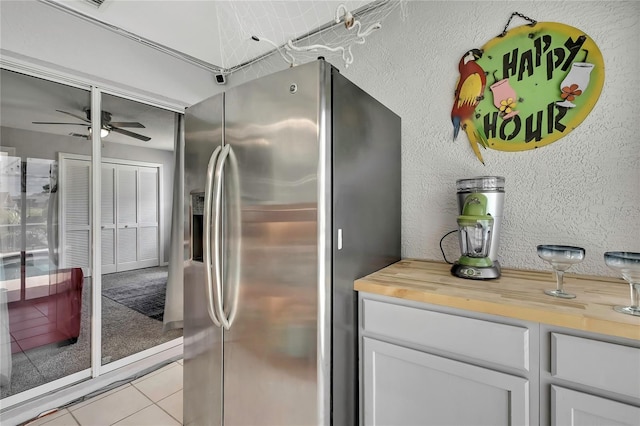 13373 Lawrence St, Spring Hill, FL 34609 - kitchen featuring ceiling fan, wooden counters, white cabinetry, light tile patterned floors, and stainless steel refrigerator with ice dispenser