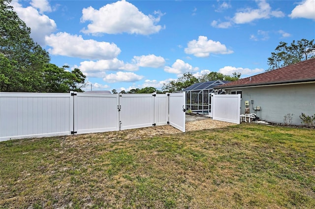 13373 Lawrence St, Spring Hill, FL 34609 - view of yard with a fenced backyard, a gate, and glass enclosure