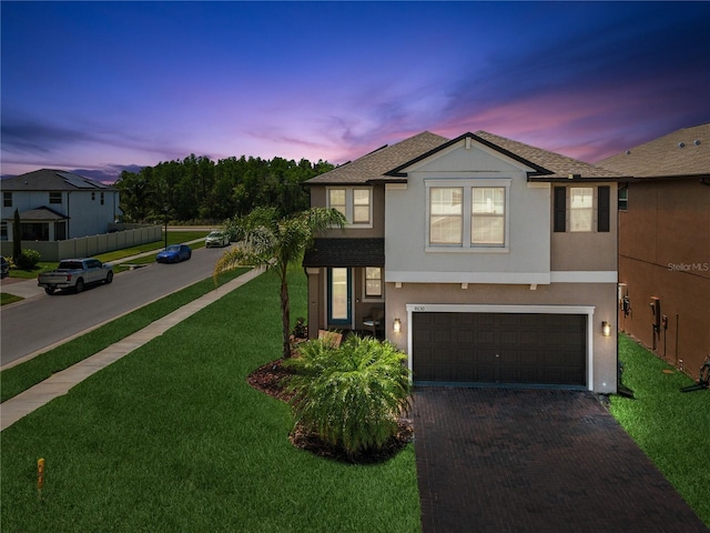 8630 Campus Woods Way, New Port Richey, FL 34655 - traditional-style house with a lawn, decorative driveway, an attached garage, a shingled roof, and stucco siding