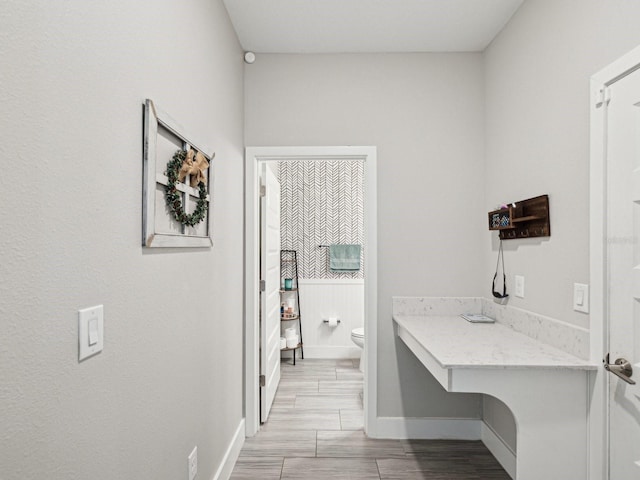 8630 Campus Woods Way, New Port Richey, FL 34655 - bathroom with baseboards, wood finished floors, and toilet