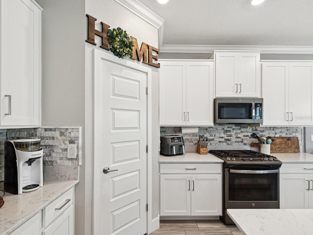 8630 Campus Woods Way, New Port Richey, FL 34655 - kitchen with backsplash, white cabinets, and stainless steel appliances