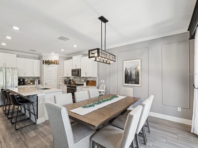 8630 Campus Woods Way, New Port Richey, FL 34655 - dining space with crown molding, wood finish floors, recessed lighting, baseboards, and visible vents