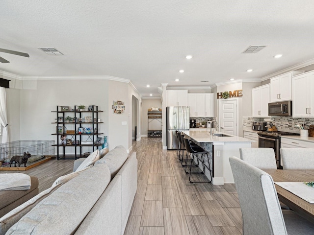 8630 Campus Woods Way, New Port Richey, FL 34655 - living room featuring crown molding, ceiling fan, and visible vents