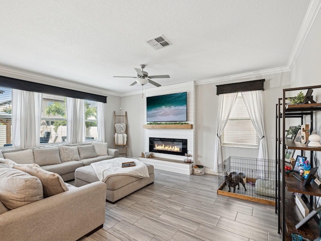8630 Campus Woods Way, New Port Richey, FL 34655 - living area with ceiling fan, a textured ceiling, visible vents, a large fireplace, and ornamental molding