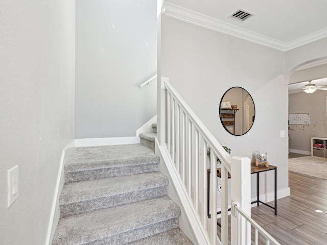 8630 Campus Woods Way, New Port Richey, FL 34655 - stairway with crown molding, a ceiling fan, arched walkways, and visible vents
