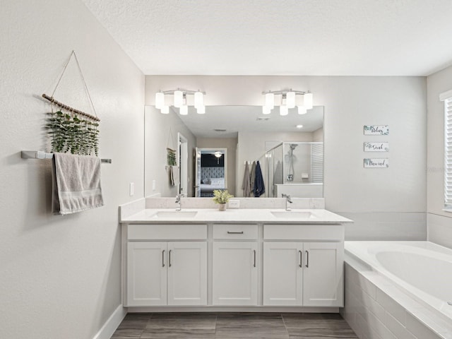 8630 Campus Woods Way, New Port Richey, FL 34655 - bathroom featuring double vanity, a sink, a bath, and a stall shower