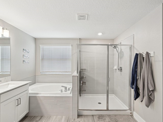 8630 Campus Woods Way, New Port Richey, FL 34655 - full bath featuring a garden tub, a textured ceiling, visible vents, a stall shower, and vanity