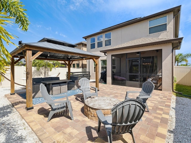 8630 Campus Woods Way, New Port Richey, FL 34655 - view of patio with a fenced backyard, an outdoor living space with a fire pit, a gazebo, and a sunroom