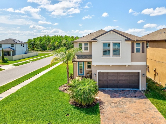 8630 Campus Woods Way, New Port Richey, FL 34655 - view of front facade featuring a garage, a front lawn, decorative driveway, stucco siding, and a shingled roof