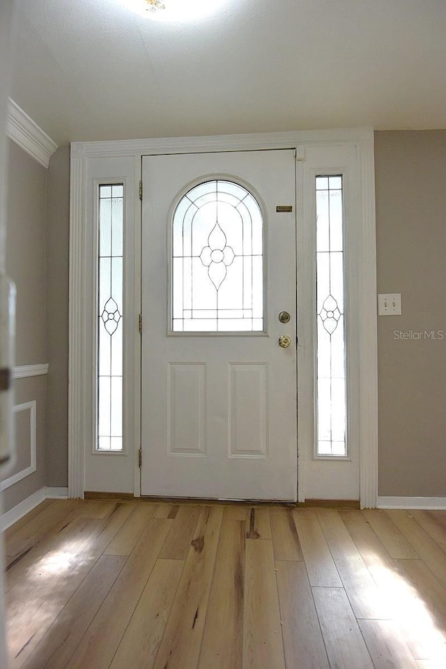 12210 Quail Run Row, Hudson, FL 34667 - entrance foyer featuring baseboards, ornamental molding, and light wood finished floors
