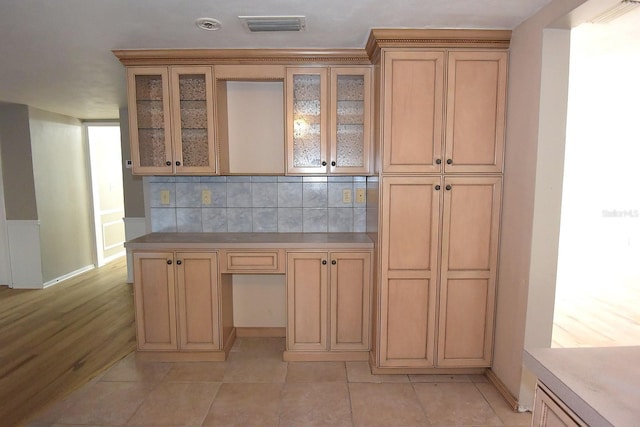 12210 Quail Run Row, Hudson, FL 34667 - kitchen with visible vents, decorative backsplash, baseboards, and glass insert cabinets
