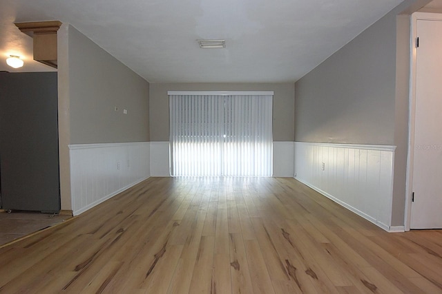 12210 Quail Run Row, Hudson, FL 34667 - unfurnished room featuring visible vents, wood finished floors, and a wainscoted wall