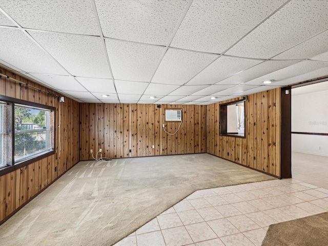interior space featuring light carpet, a drop ceiling, wooden walls, an AC wall unit, and recessed lighting