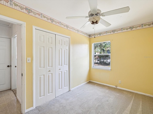 unfurnished bedroom featuring baseboards, carpet flooring, ceiling fan, and a closet