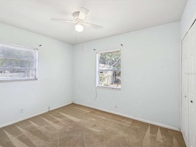 spare room featuring baseboards, carpet flooring, and ceiling fan