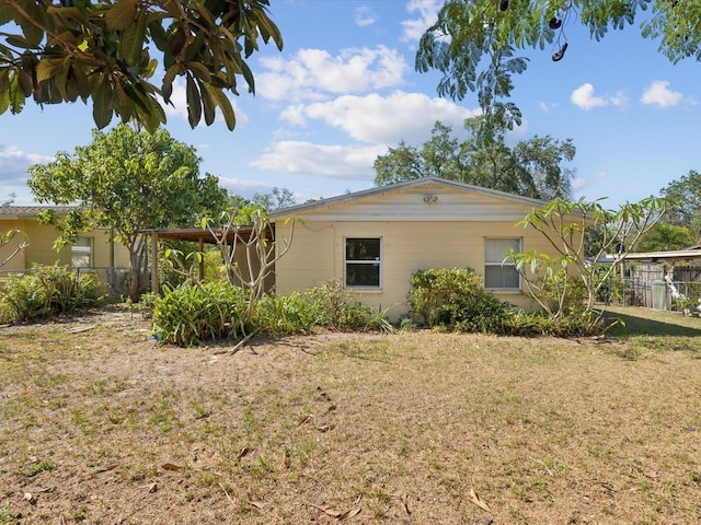 view of home's exterior with fence and a lawn