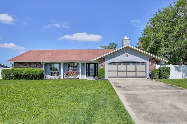 ranch-style home featuring fence, an attached garage, stone siding, a front yard, and concrete driveway