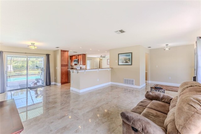 living area featuring visible vents, marble finish floor, and baseboards