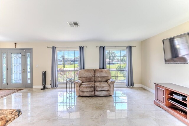 living room with baseboards, marble finish floor, and visible vents