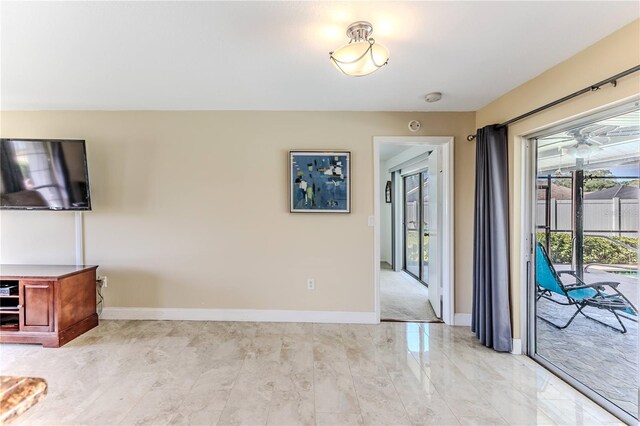 unfurnished living room with baseboards