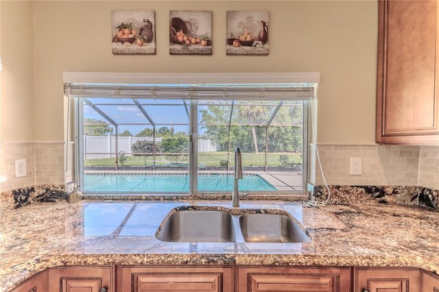 kitchen with a sink, decorative backsplash, and a wealth of natural light