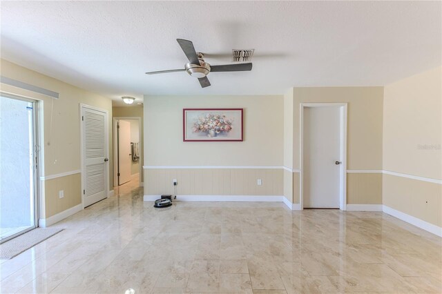 empty room with baseboards, marble finish floor, ceiling fan, and visible vents