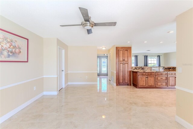 interior space featuring a ceiling fan and marble finish floor