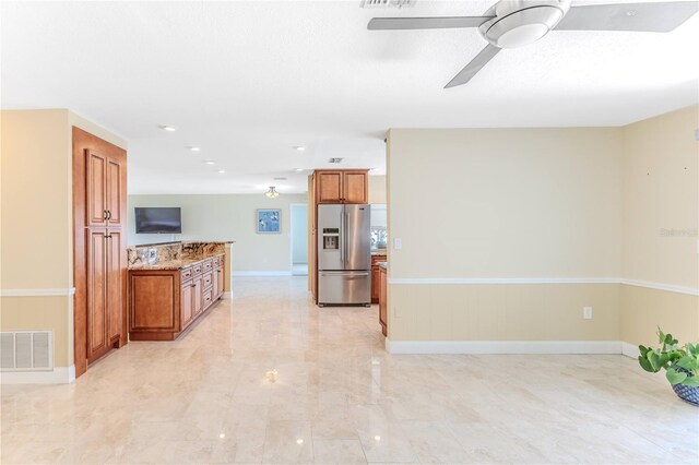 kitchen with stainless steel fridge with ice dispenser, a ceiling fan, brown cabinets, and visible vents