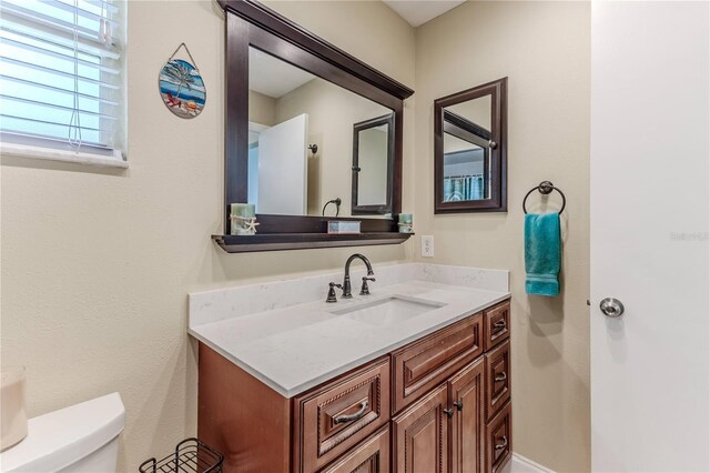 half bathroom featuring vanity and toilet