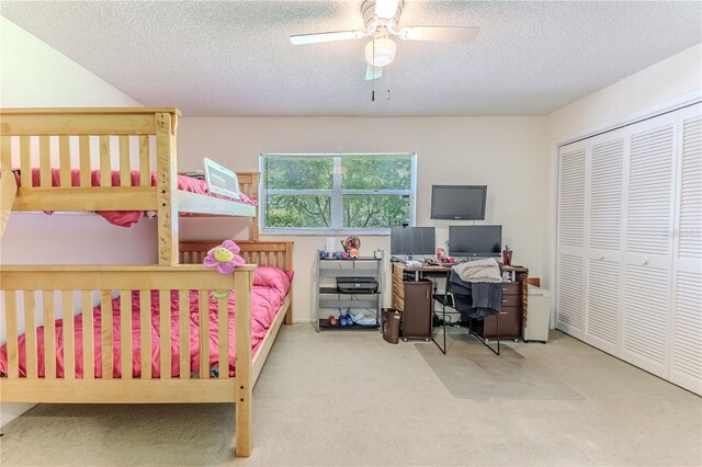 carpeted bedroom featuring a ceiling fan, a textured ceiling, and a closet