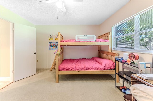 bedroom with carpet flooring, a ceiling fan, and a textured ceiling