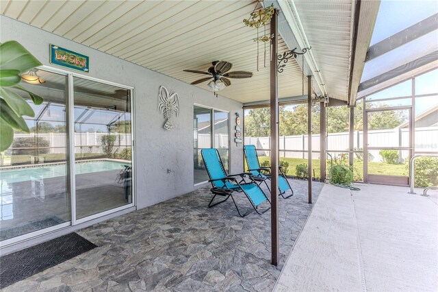 unfurnished sunroom with a ceiling fan and a wealth of natural light