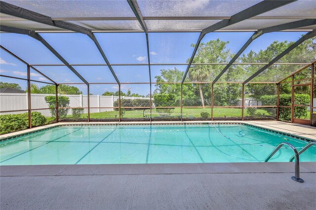 outdoor pool featuring glass enclosure and a fenced backyard