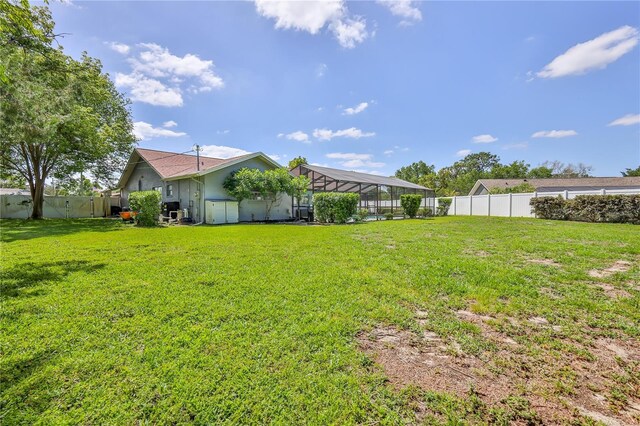 view of yard with a fenced backyard and a lanai