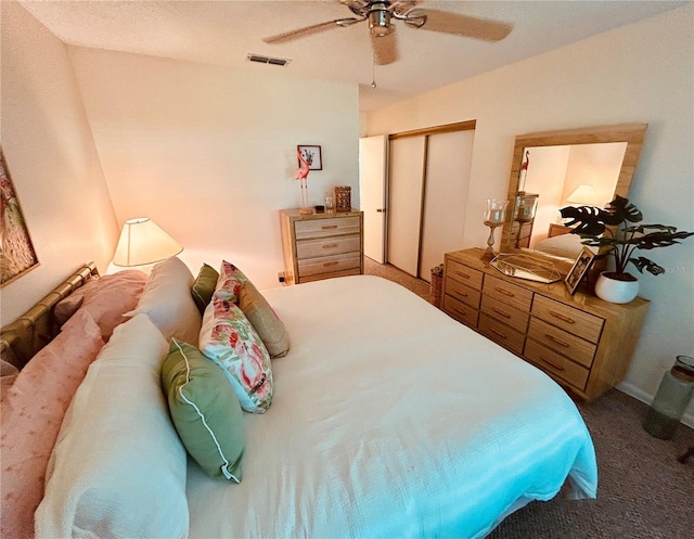 carpeted bedroom featuring visible vents, ceiling fan, and a closet