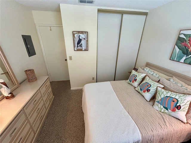 carpeted bedroom with electric panel, a closet, and visible vents