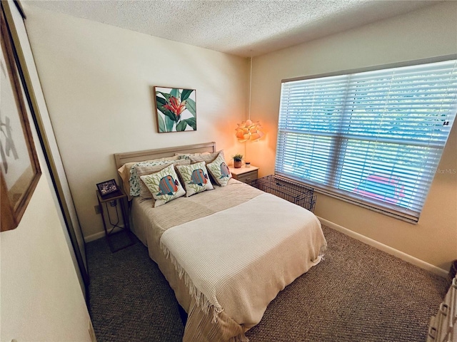 bedroom with baseboards, carpet flooring, and a textured ceiling