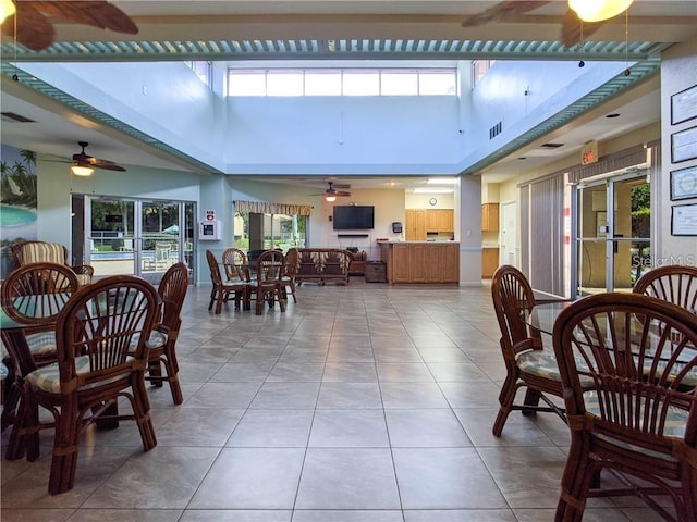 interior space featuring light tile patterned floors, ceiling fan, and a skylight