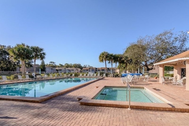 pool with a patio and fence