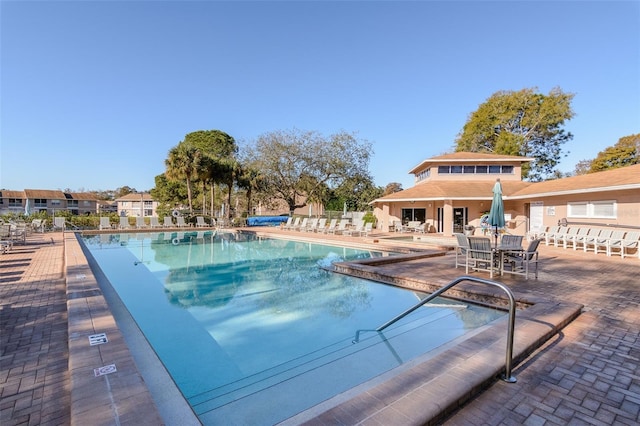 community pool with fence and a patio area