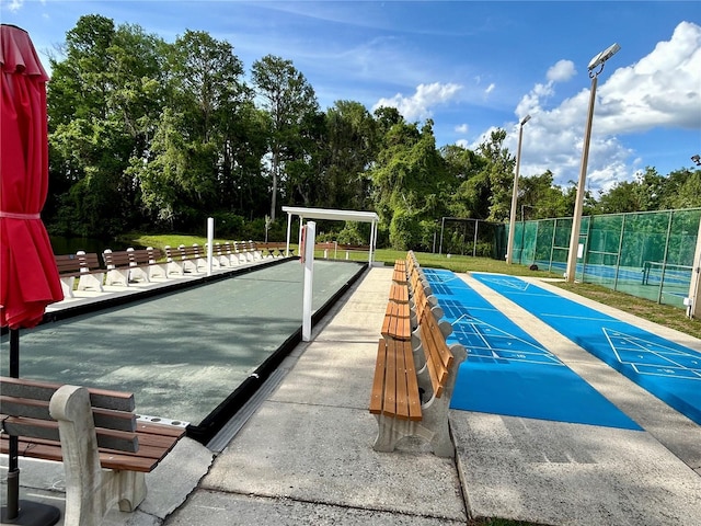 surrounding community with fence and shuffleboard