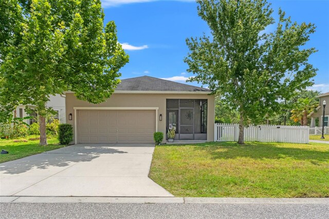 21167 Pleasant Plains Pkwy, Land O Lakes, FL 34637 - view of front of house featuring a front yard, an attached garage, a sunroom, and stucco siding