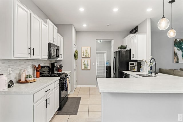 21167 Pleasant Plains Pkwy, Land O Lakes, FL 34637 - kitchen featuring backsplash, a sink, white cabinets, black appliances, and a peninsula