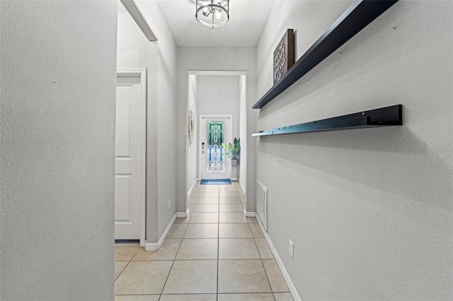 21167 Pleasant Plains Pkwy, Land O Lakes, FL 34637 - hallway with baseboards, a textured wall, and light tile patterned flooring
