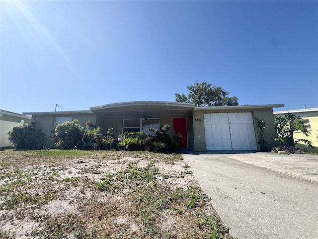 single story home featuring concrete driveway, stucco siding, a ceiling fan, and a garage